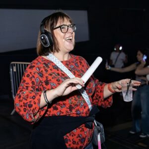 Guest laughing with a foam light stick at a silent disco