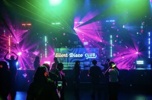 Silent Disco Club DJ booth under pink lasers with dancers