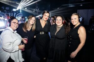 Group of six friends in silent disco headphones