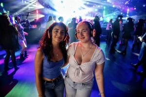 Two friends on a lit-up silent disco dance floor