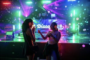 Two guests dancing at the stage among bubbles and colour