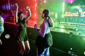 Guests dancing at a red and green lit stage