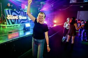 Guest dancing with an arm raised in front of the booth