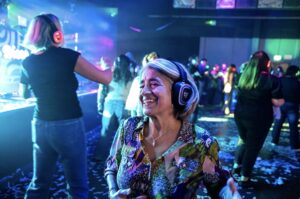 Guest smiling on a bubble-filled silent disco dance floor