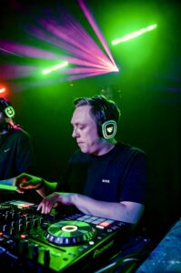 DJ mixing under green and pink lasers