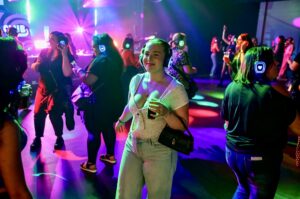 Silent disco dance floor crowd under purple and green lights
