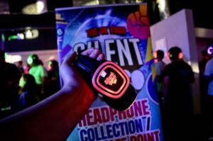 Glowing Silent Disco Club headphones held up at the collection point