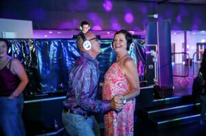 Couple dancing together in silent disco headphones