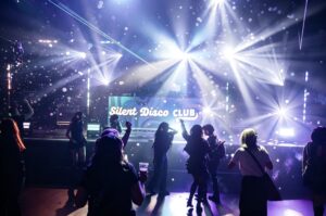 Dance floor under white light beams at the Silent Disco Club booth